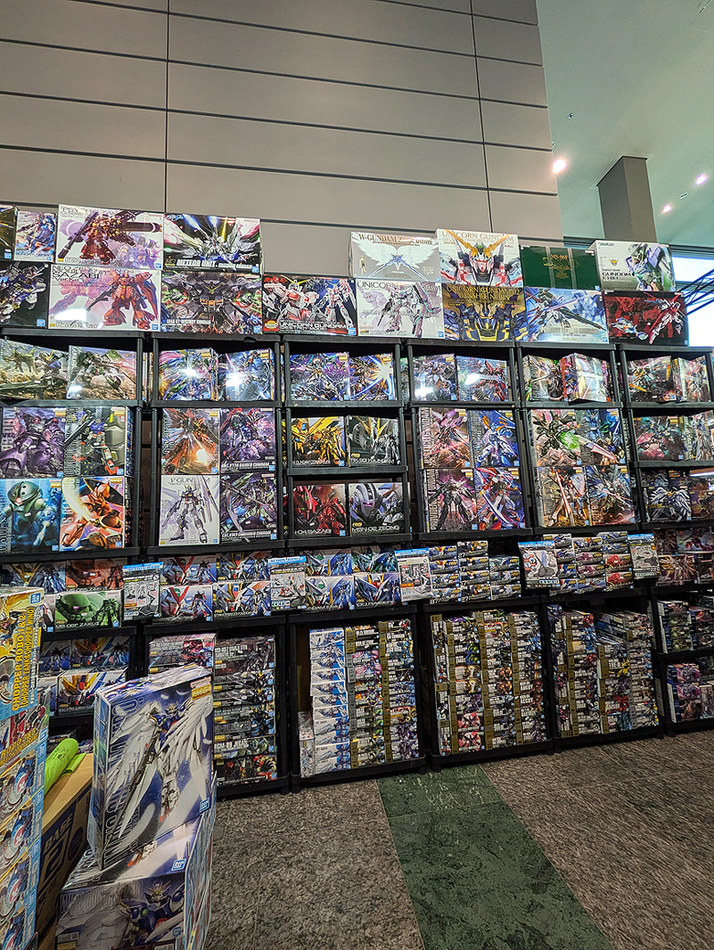 a giant wall of boxed gunpla at the dealers hall